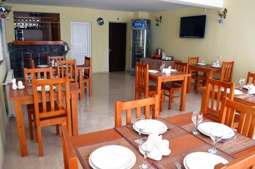a dining room with wooden tables and chairs at Hotel Toni in Gudauri