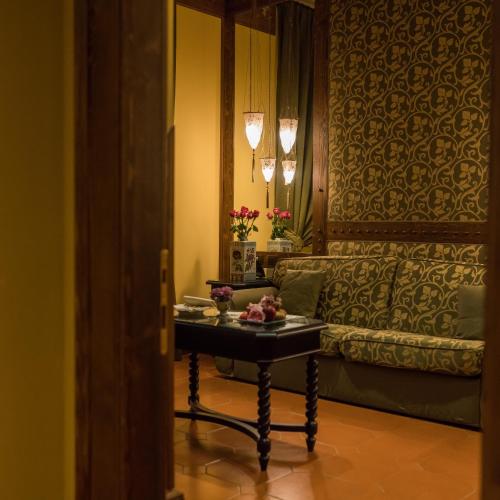 a living room with a table and a couch at Hotel Bernini Palace in Florence