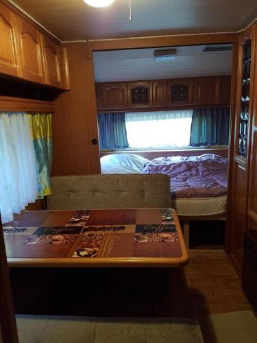 Habitación con sofá y cama en una cabaña en Mietwohnwagen, en Lonau