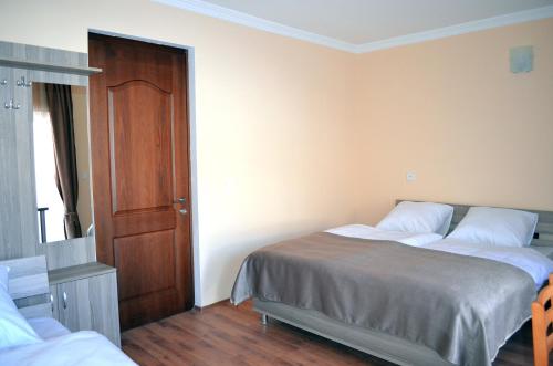 a bedroom with two beds and a wooden door at Hotel Toni in Gudauri