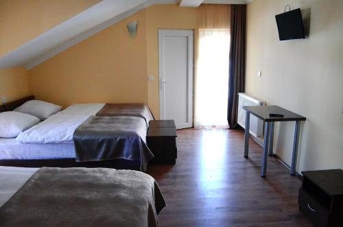 a hotel room with two beds and a television at Hotel Toni in Gudauri