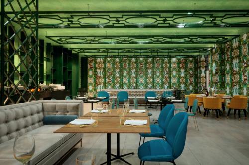 a dining room with tables and blue chairs at Leonardo Boutique Jerusalem in Jerusalem