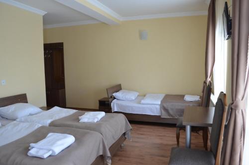 a hotel room with two beds with towels on them at Hotel Toni in Gudauri