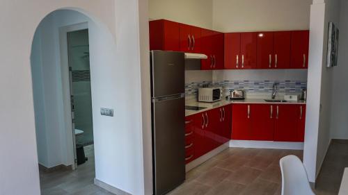 una cucina con armadi rossi e frigorifero di Apartment Old Town Reina Sofia 1 a Puerto del Carmen
