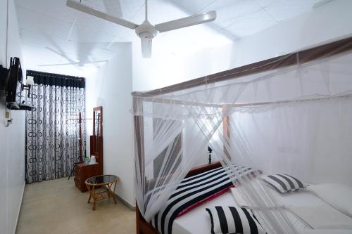 a bedroom with a bed with a ceiling fan at Hotel City Grand Ella in Ella