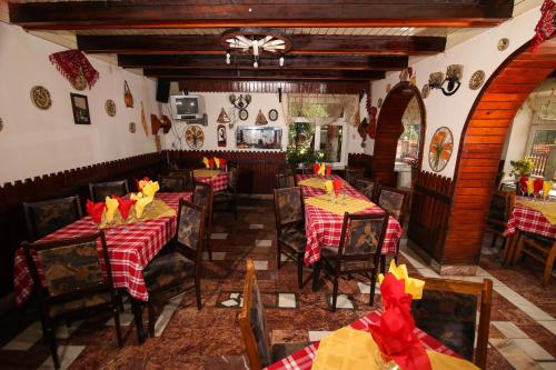 un restaurante con mesas y sillas con manteles rojos y amarillos en Vila Cotul Donului, en Timisu de Sus