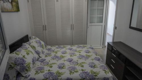 Un dormitorio con una cama con flores púrpuras. en Apartment Old Town Reina Sofia 2, en Puerto del Carmen