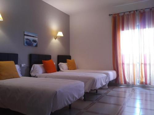 a hotel room with two beds and a window at Hotel Perú by Bossh! Hotels in Trujillo