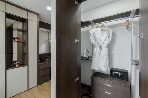 a bathroom with a white shirt hanging on a closet at Elite Apart-Hotel in Astana