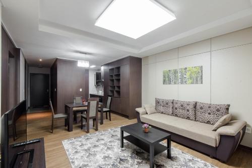 a living room with a couch and a table at Elite Apart-Hotel in Astana