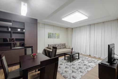 a living room with a couch and a table at Elite Apart-Hotel in Astana