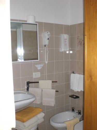 bagno con lavandino, servizi igienici e specchio di Albergo Pensione Serenetta a Varena