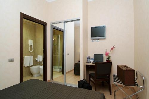a hotel room with a bed and a desk with a computer at EH Rome Airport Euro House Hotels in Fiumicino