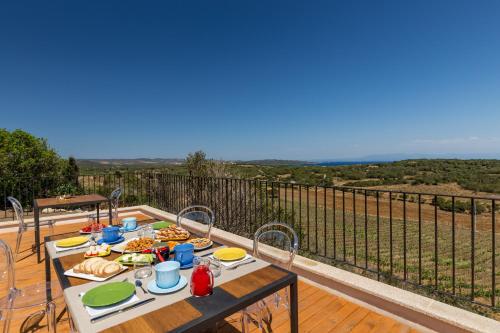 a table with food on top of a balcony with a view at Tenuta Petra Bianca in Palau