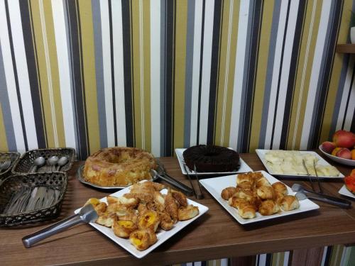 a table with several plates of food on it at Rivero Hotel in Chuí