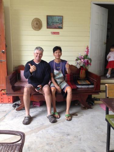 a man and a woman sitting on a bench at Milin Guesthouse in Chiang Rai