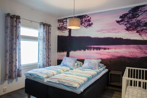 a bedroom with a bed with a painting on the wall at Lumikko Villa in Sonka