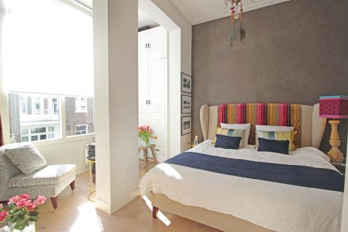 a bedroom with a bed and a chair and a window at Vondelpark Suite in Amsterdam