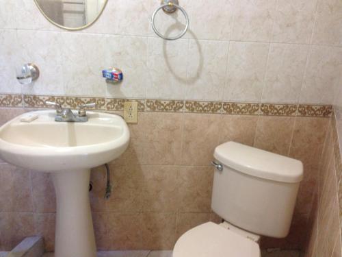 a bathroom with a sink and a toilet and a mirror at Brisas 54632 in Monterrey