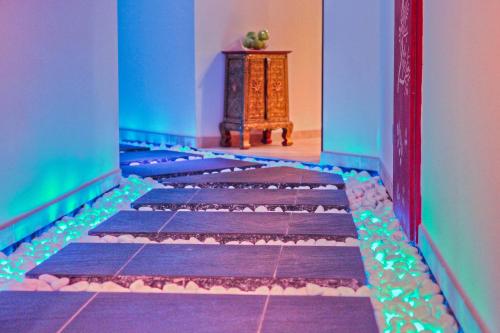 a corridor with a blue and purple room with a table at SEETELHOTEL Ahlbecker Hof das elegante Traditionshotel & ruhiger Rückzugsort an der Ostsee in Ahlbeck