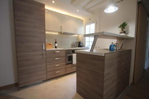 une cuisine avec des armoires en bois et un comptoir dans l'établissement MAGNIFIQUE 5 PIECES, à Paris