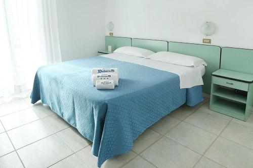 リミニにあるHotel Doloresのベッドルーム1室(青い毛布付きのベッド1台付)