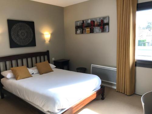 a bedroom with a white bed and a window at l'auberge in Gamarde-les-Bains