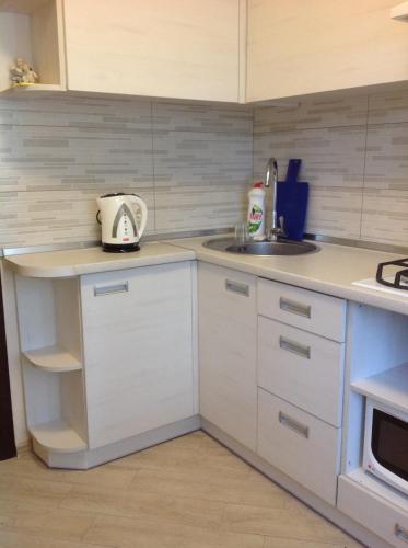 a kitchen with white cabinets and a sink at Квартира in Kyiv