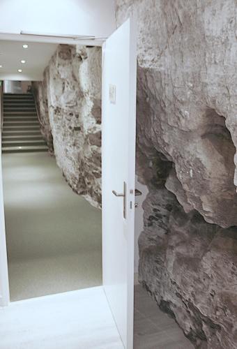 a door into a hallway with a stone wall at Hôtel Restaurant Plaisance-Piscine couverte et chauffée- Proche Sarlat- in Vitrac
