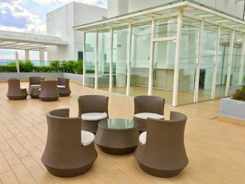eine Lobby mit Stühlen und Tischen sowie ein Gebäude in der Unterkunft Pinnacle Tower Apartment Stay by Feel Suites in Johor Bahru