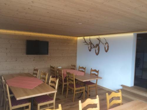 a dining room with tables and chairs and a flat screen tv at Hotel Restaurant Heidihof in Maienfeld