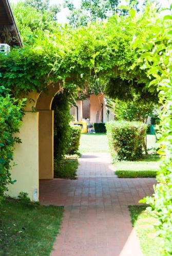 a garden with an archway with a brick path at The Garda Village in Sirmione