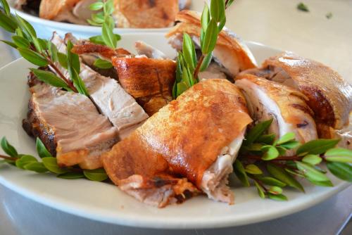 a plate of food with meat and greens on it at Agriturismo Orvile in Posada