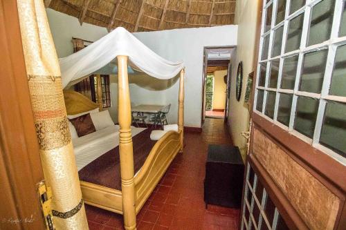 a bedroom with a bed with a canopy at Governors Club in Entebbe
