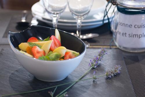 a bowl of fruit on a table with wine glasses at l'auberge in Gamarde-les-Bains