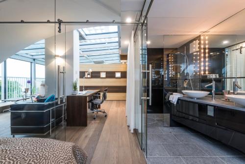 a bathroom with two sinks and a desk at SEEhotel Friedrichshafen in Friedrichshafen