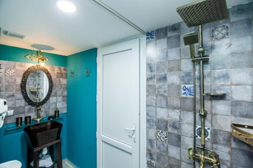 a bathroom with blue walls and a shower at Tiflis Inn Boutique Hotel in Tbilisi City