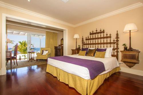 a bedroom with a large bed and a living room at Villa Mila in Puerto Calero