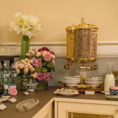 a table with flowers and plates and a chandelier at Hotel Bernini Palace in Florence
