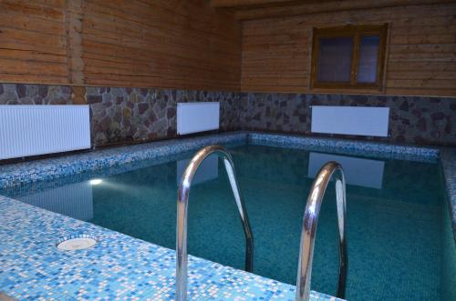 una piscina con 2 grifos en una habitación en Chateau Royal Hotel, en Berezovka