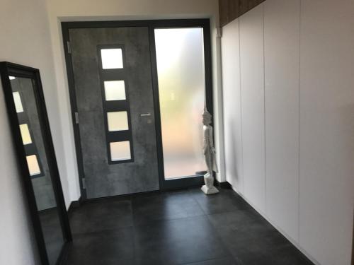 pusty korytarz z drzwiami i oknem w obiekcie Ferienappartement Vastu w mieście Pflach