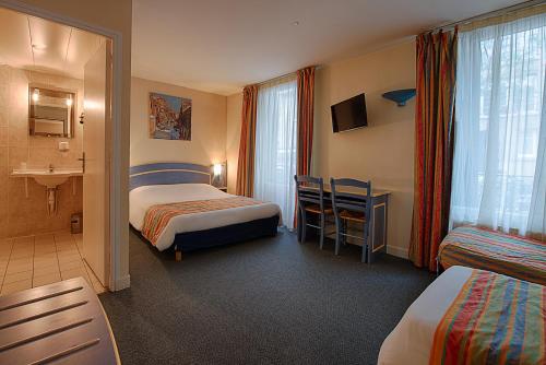 um quarto de hotel com duas camas e uma casa de banho em Le Ruisseau em Saint-Mandé