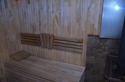 a wooden bathtub with a bench in a room at Chateau Royal Hotel in Berezovka