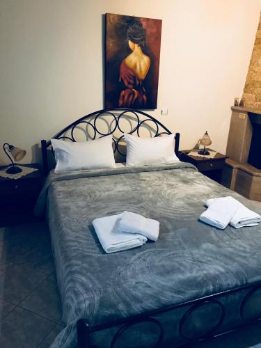 a bedroom with a bed with two towels on it at Guesthouse Adonis in Kato Loutraki