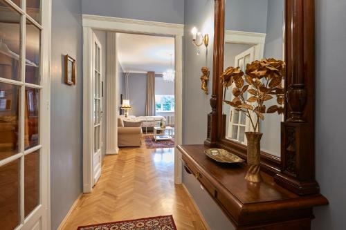 a hallway with a mirror and a table with a plant at Schieszl Apartments 1 in Budapest