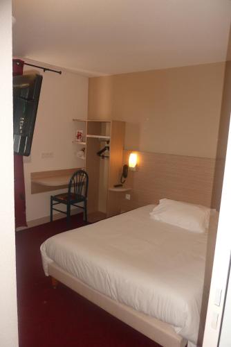 a hotel room with a bed and a desk at The Originals City, Hôtel Hélios, Roanne Nord in Mably