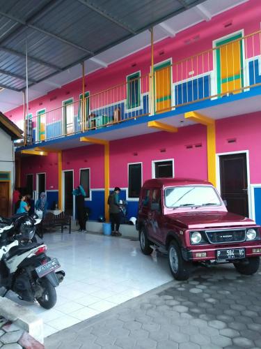 a red jeep parked in front of a building at Homestay Lidiya in Banyuwangi
