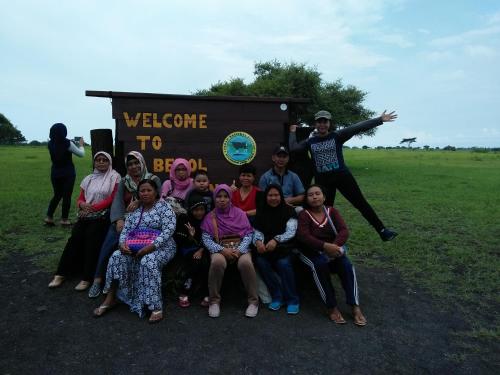 a group of people posing in front of a welcome sign at Homestay Lidiya in Banyuwangi