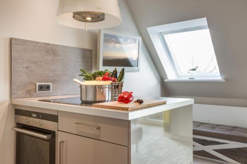 a kitchen with a counter with a sink and a window at Apartmenthotel am Leuchtturm in Hörnum