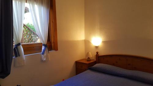 a bedroom with a bed and a window at Residenze Coda Cavallo in San Teodoro